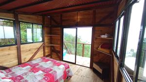 a bedroom with a bed in a room with windows at Buena Vista Ecohotel in Los Medios