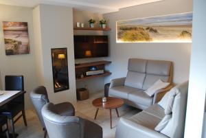 ein Wohnzimmer mit einem Sofa und einem Tisch in der Unterkunft Hotel Rubens in De Haan