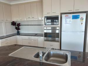 a kitchen with a sink and a white refrigerator at Pelicans Drift in Harrington
