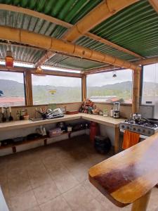 a kitchen with a table and a stove and windows at Golden Bird in Mindo