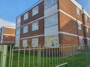 ein Backsteingebäude mit einem Zaun davor in der Unterkunft A home in the city in London
