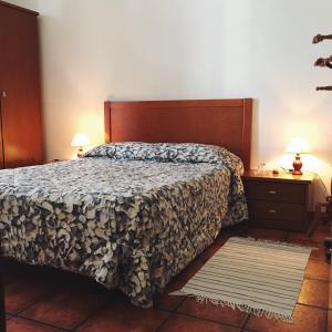 a bedroom with a bed and two night stands and two lamps at Alojamento Baixa Mar in Vila Real de Santo António