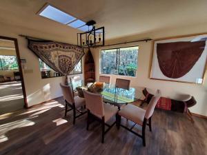 a dining room with a glass table and chairs at ʻOhiʻa Lehua Forest House in Volcano