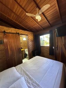 a bedroom with a large bed with a ceiling fan at Cabana Fé Miguel Pereira Chalé Para Casal no Centro MP in Miguel Pereira