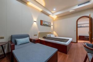 a room with a bed and a chair and a table at Kaibu Courtyard Superior Apartment, Changjiang Cable Car Nanbin Road, Chongqing in Chongqing