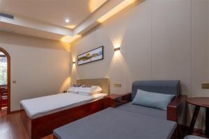 a small room with two beds and a chair at Kaibu Courtyard Superior Apartment, Changjiang Cable Car Nanbin Road, Chongqing in Chongqing