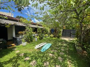 un patio con una tabla de surf sobre la hierba en Aira Place, en Weligama