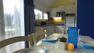 une cuisine avec une table blanche et un mur bleu dans l'établissement VVF Les Plages de Guérande La Turballe, à La Turballe