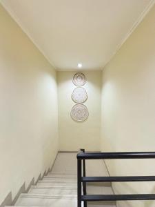 TimuranYogya Holiday Villa的墙上和楼梯上有两个板的房间 更多2张照片