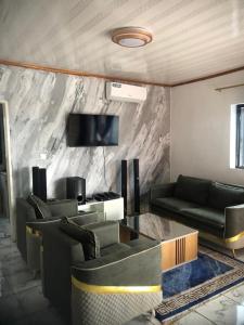 een woonkamer met twee banken en een tv bij Papi House in Limbe +4 foto's