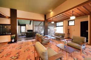 a living room with couches and chairs and a table at Otogitei Kofu in Achi