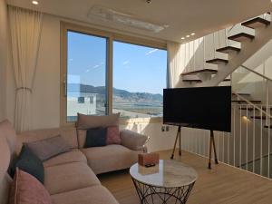 a living room with a couch and a flat screen tv at Oceanview,Villa de 427 in Seogwipo