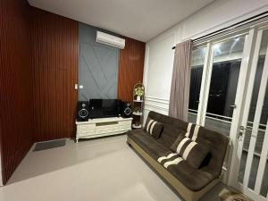 a living room with a couch and a television at Villa Sunrise F1 in Malang