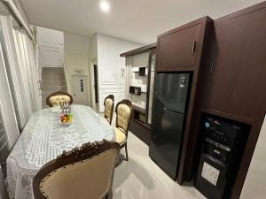 a kitchen with a table with chairs and a refrigerator at Villa Sunrise F1 in Malang