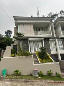 a large house with stairs and plants in front of it at Villa Sunrise F1 in Malang
