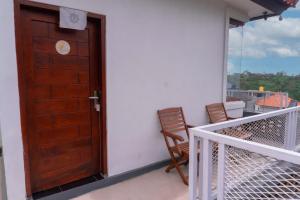 a wooden door on a balcony with two chairs at Aurora Holiday House Kintamani in Kintamani