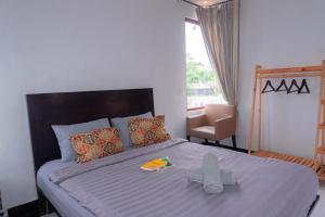 a bedroom with a bed with a blue comforter and a chair at Aurora Holiday House Kintamani in Kintamani