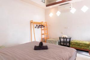 a bedroom with a bed and a ladder and a chair at Aurora Holiday House Kintamani in Kintamani