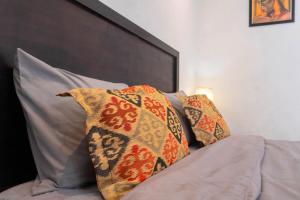 a group of pillows sitting on top of a bed at Aurora Holiday House Kintamani in Kintamani