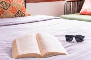 a book and a bow tie sitting on a bed at Aurora Holiday House Kintamani in Kintamani
