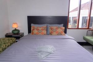 a bedroom with a bed with a white towel on it at Aurora Holiday House Kintamani in Kintamani