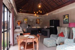 a living room with a table and chairs and a kitchen at Aurora Holiday House Kintamani in Kintamani