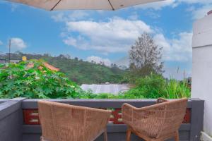two chairs sitting on a balcony with a view at Aurora Holiday House Kintamani in Kintamani