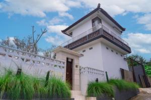 a white building with a roof at Aurora Holiday House Kintamani in Kintamani
