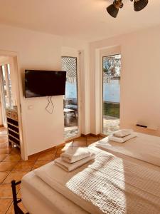 a bedroom with two beds and a flat screen tv at TheBlue Oak Apartments in Rust