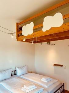 two beds in a room with white clouds on the ceiling at TheBlue Oak Apartments in Rust +28 photos