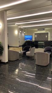 a lobby with a piano and chairs and a table at ليلك سويت للشقق المخدومة in Taif