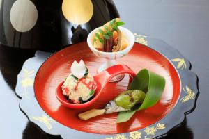 a red plate with some food on a table at Otogitei Kofu in Achi