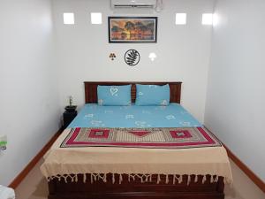 a bedroom with a bed with a blue comforter at Araliya Villa in Seeduwa