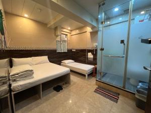 香港3D Inn Hong Kong - Dragon的客房设有两张床和玻璃淋浴间。