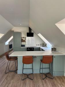 a kitchen with a counter and two stools at Dukes Flat in Ampney Saint Peter