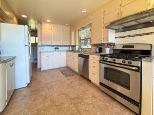 una cocina con estufa y refrigerador en Sq Secret Shores, en Sequim