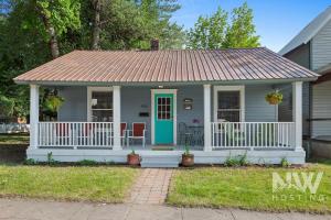 Ce cottage dispose d'une terrasse couverte et d'une porte bleue. dans l'établissement Lakeside Bungalow, à Coeur d'Alene
