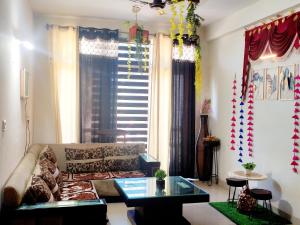 a living room with a couch and a table at Budget Condo Family Stay 2 BHK in Mohali