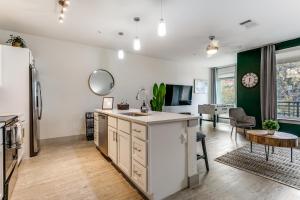 an open kitchen and living room with a refrigerator at Modern Cozy Condo facing Riverwalk w King Suite in San Antonio