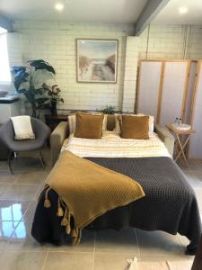 a bedroom with a bed and a chair in it at Water Street - Garden Views in Forster