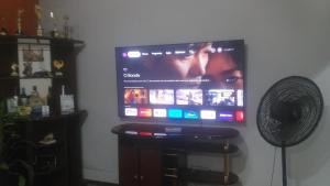 a flat screen tv on a wall with a fan at Chacara bella vitta in Socorro