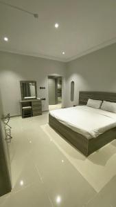 a bedroom with a large bed and a sink at ليلك سويت للشقق المخدومة in Taif +16 photos
