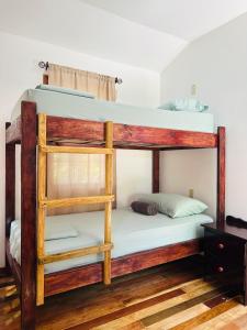 two bunk beds in a room with wooden floors at Silver Sand, Placencia in Placencia