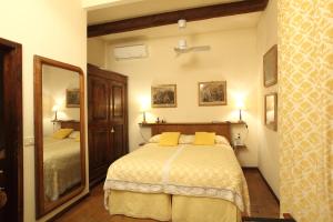 a bedroom with a bed with yellow pillows and a mirror at Rovezzano B&B in Florence