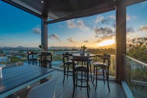 d'une terrasse avec tables et chaises et vue sur le coucher du soleil. dans l'établissement Luxury Seaview Villa 6BR - Villa Shine, à Ban Saiyuan (1)