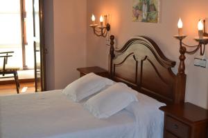 a bedroom with a bed with white sheets and two pillows at Posada Las Puentes in Barcenilla