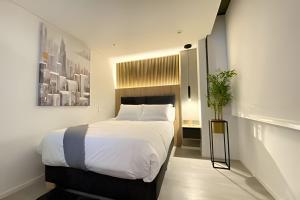 una camera da letto con un grande letto bianco in una stanza di Frag a Bogotá