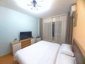 Voodi või voodid majutusasutuse Qingdao Mi Apartment toas