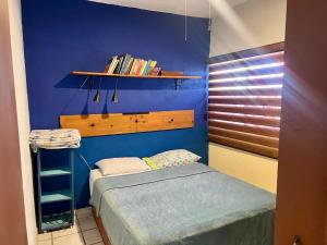 a small bedroom with a bed and a blue wall at La casa del pescador in La Paz