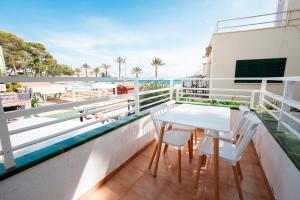 ein Balkon mit Tisch und Stühlen und dem Meer in der Unterkunft Nura Houses Magaluf Beach - Superior Apt in Magaluf